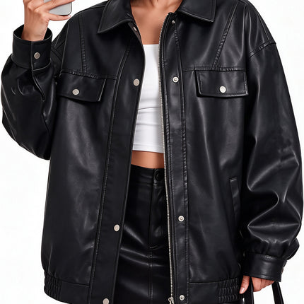 Woman modeling women's oversized black faux leather zip-up utility bomber jacket, front view